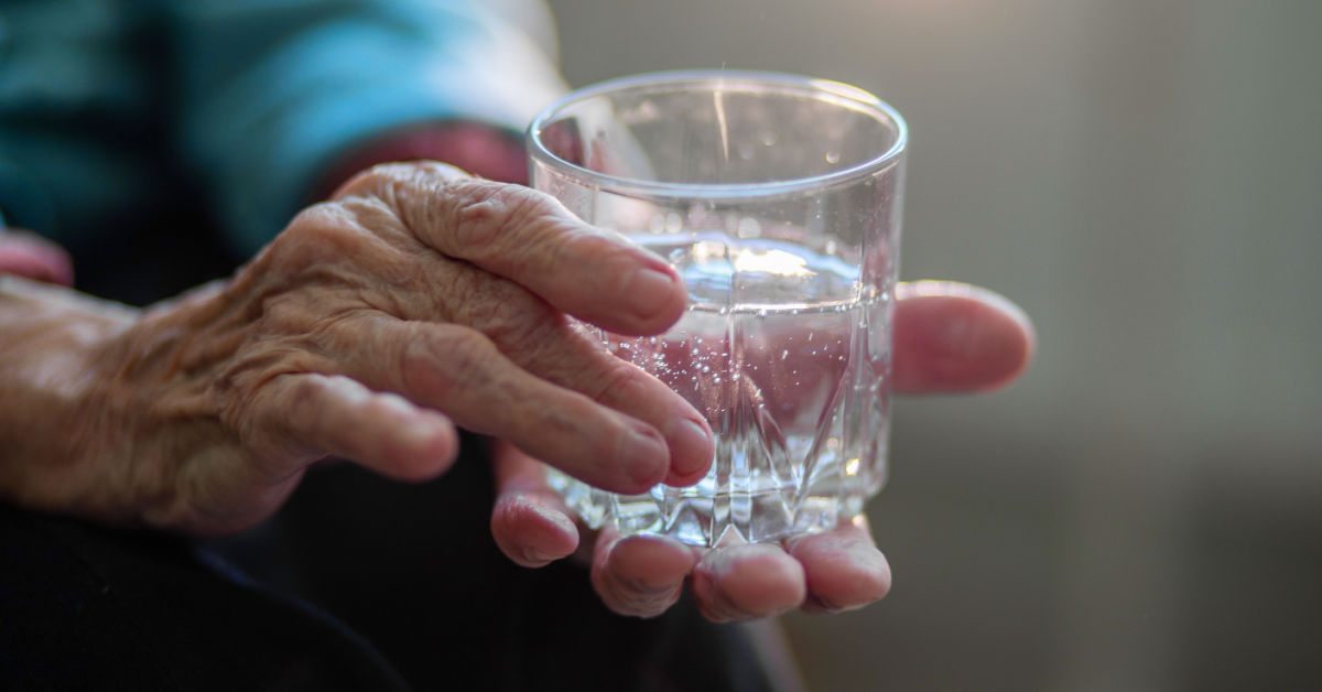 Dehydration & malnutrition in nursing homes with elderly woman with glass of water